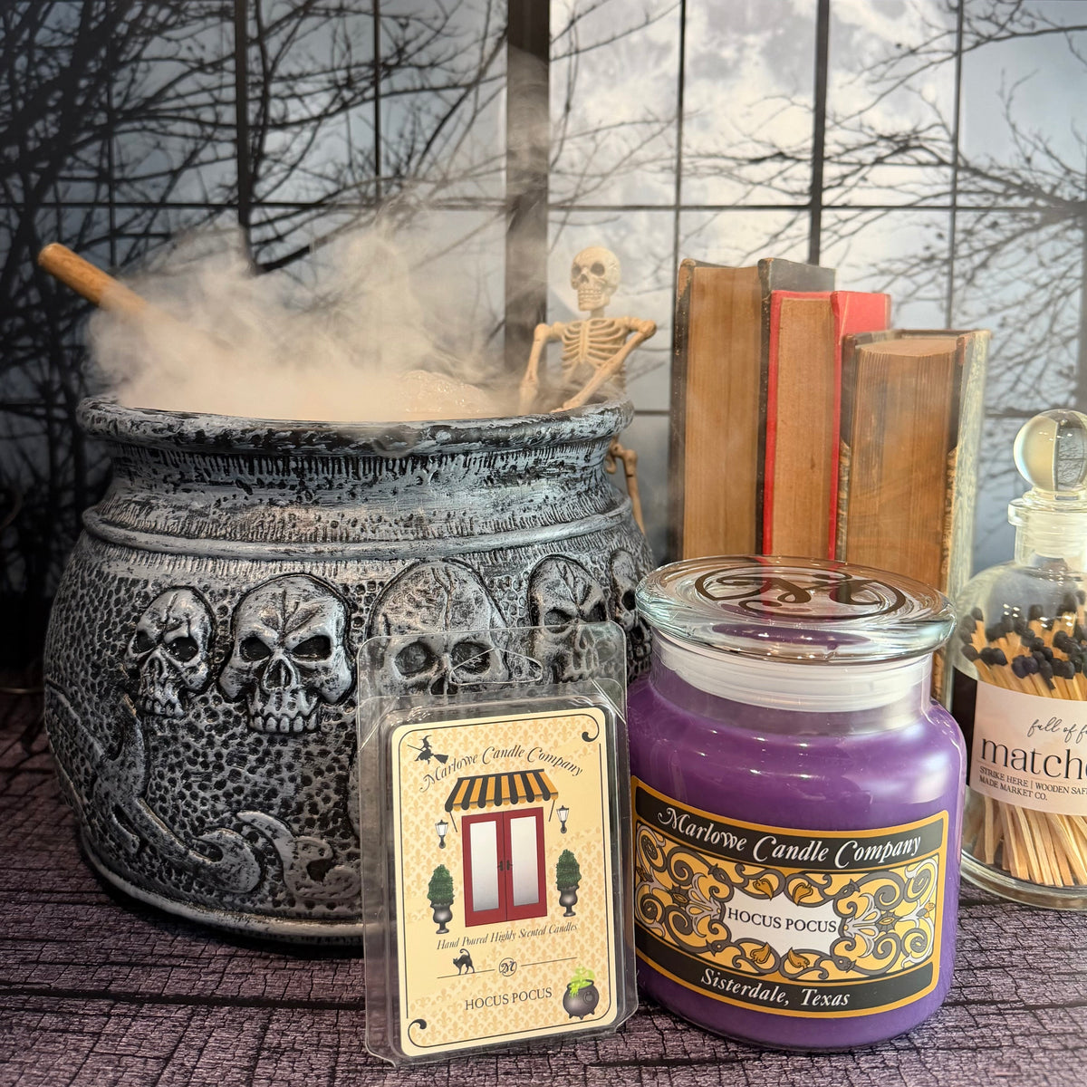 Hocus Pocus candle and wax melt displayed with spooky Halloween cauldron and skeleton decor.