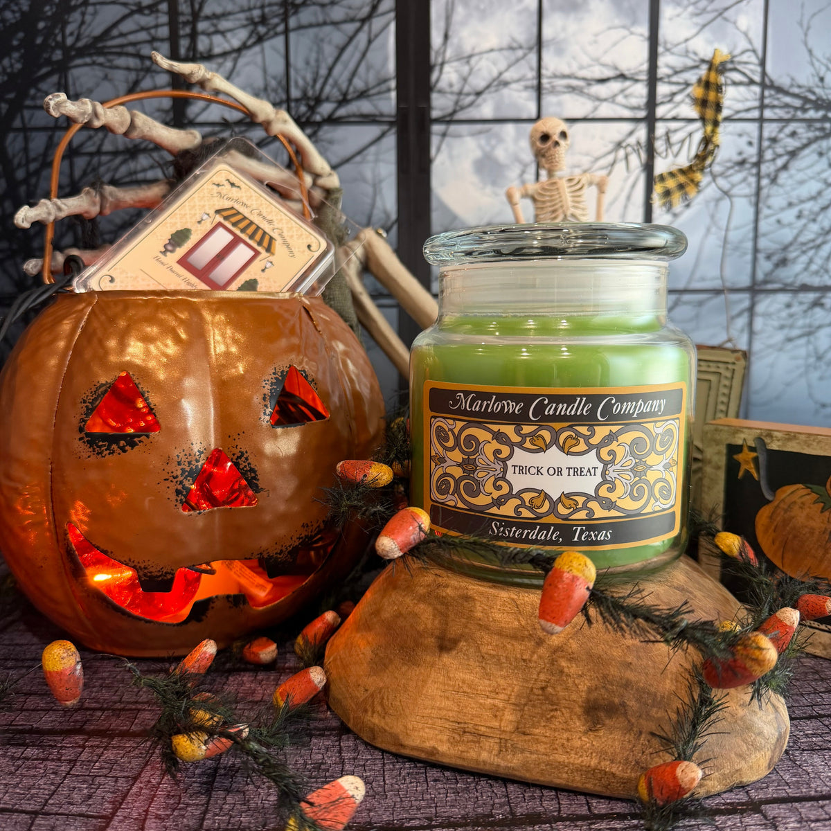 Trick or Treat candle and wax melt displayed with glowing jack-o'-lantern and Halloween candy corn decor.